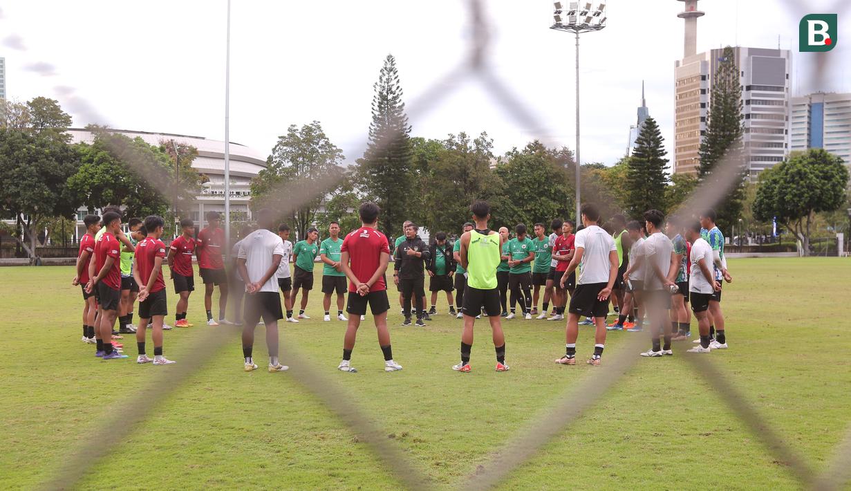 Pelatih Timnas Indonesia, Indra Sjafri, memberikan arahan kepada anak asuhnya saat sesi latihan di Lapangan A Senayan, Jakarta, Jumat (19/2/2024). (Bola.com/M Iqbal Ichsan)