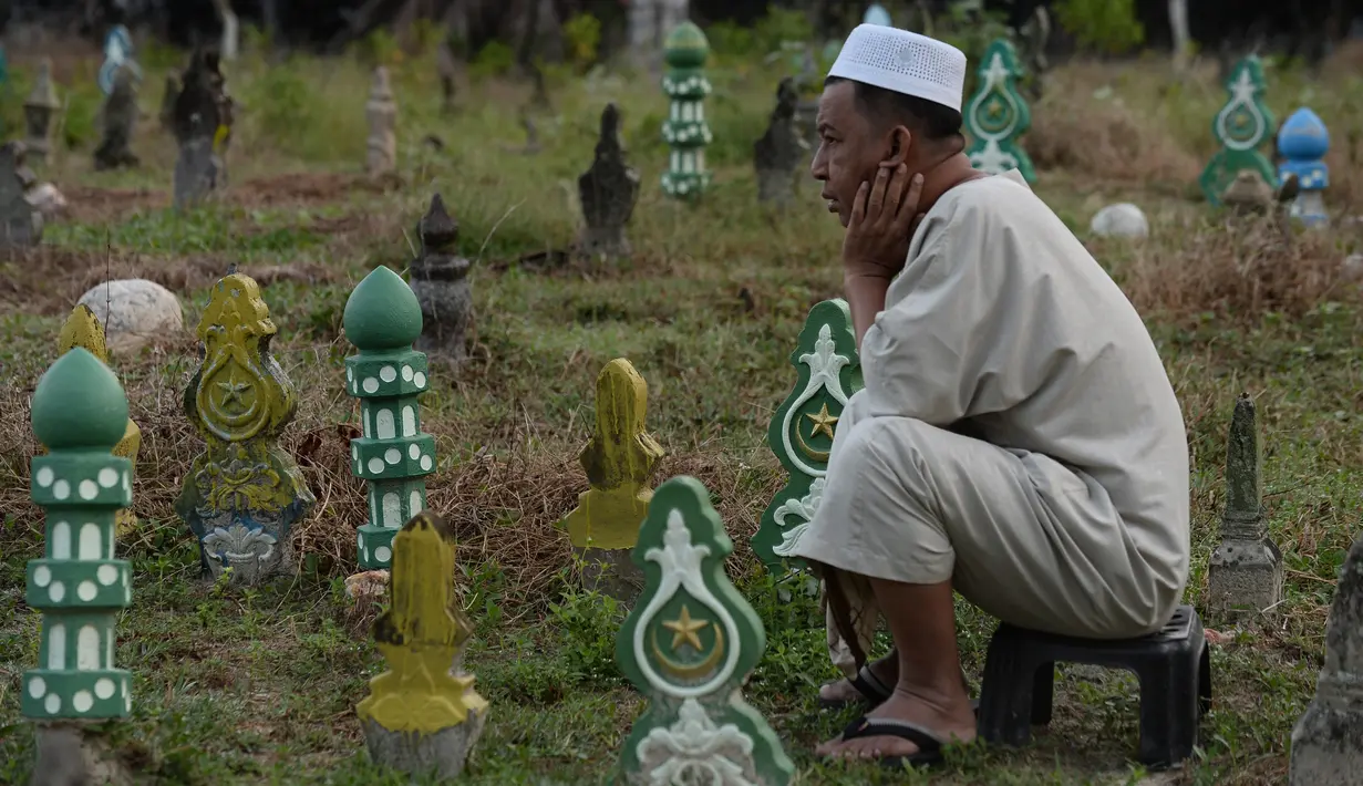 Seorang muslim Thailand melakukan ziarah kubur pada perayaan Idul Adha di provinsi Narathiwat, Minggu (11/8/2019). Pada setiap Idul Adha atau menyambut hari besar Islam sebagian warga banyak mendatangi kuburan untuk mendoakan keluarganya. (Madaree TOHLALA/AFP)