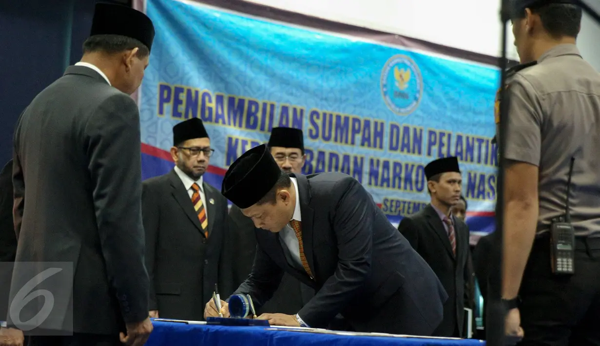 Komjen Pol Budi Waseso menandatangi berkas acara pelantikan dirinya sebagai Kepala BNN di Kantor BNN, Jakarta, Selasa (8/9). Buwas resmi menggantikan Komjen Pol Anang Iskandar sebagai Kepala BNN. (Liputan6.com/Faizal Fanani)
