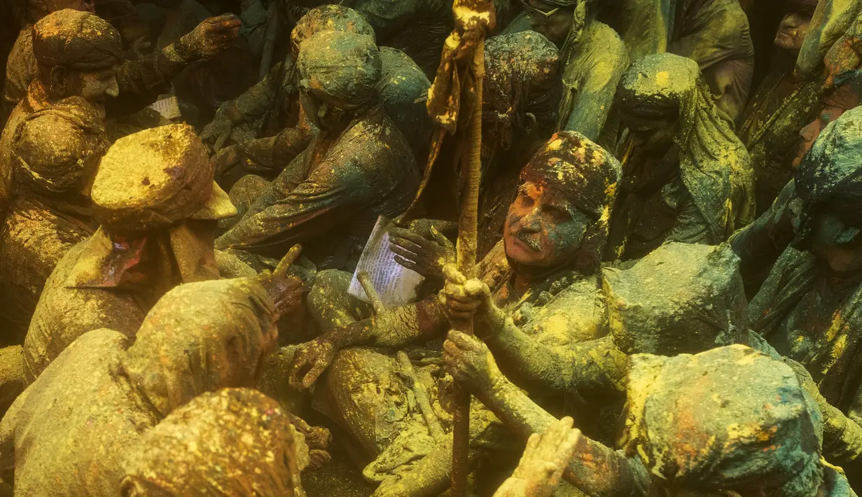 Umat Hindu mengambil bagian dalam pertemuan tradisional selama perayaan Lathmar Holi di sebuah kuil di Barsana, India, Selasa (23/3/2021). Perayaan ini berlangsung di kuil Radha Rani di Barsana, India, yang merupakan satu-satunya kuil Holi yang didedikasikan untuk Dewi Radha. (Xavier GALIANA/AFP)