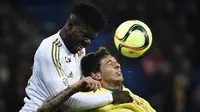 5. Samuel Umtiti (kiri), bek Lyon yang masih berusia 22 tahun ini menjadi incaran dari Tottenham. Namun menurut Mirror, untuk mendapatkannya Spurs harus bersaing dengan raksasa Prancis, PSG. (AFP/Jeff Pachoud)