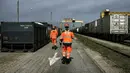 Sejumlah pekerja berjalan di stasiun kereta api barang di Saint-Priest, Lyon Prancis, (21/4). Untuk pertama kali, kereta barang yang mengangkut 41 kontainer dari China tiba di Prancis. (AFP PHOTO/JEFF PACHOUD)