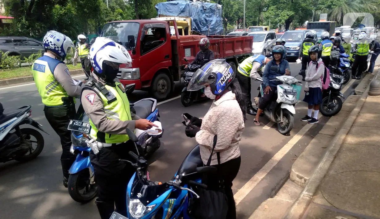 Polisi memeriksa surat kendaraan saat razia di kawasan BSD, Tangerang Selatan, Banten, Kamis (23/1/2020). Polres Tangerang Selatan menggelar razia untuk meningkatkan tertib berlalu lintas, disiplin kendaraan, dan mempersempit gerak pelaku kejahatan jalanan. (merdeka.com/Arie Basuki)