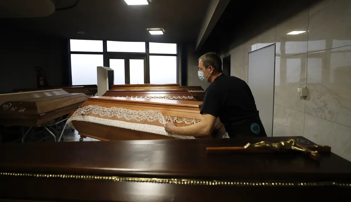 Seorang pekerja memindahkan peti jenazah untuk dibakar di sebuah krematorium di Ostrava, Republik Ceko pada 7 Januari 2021. Krematorium terbesar di Ceko dan satu-satunya di wilayah itu telah kewalahan dalam mengkremasi jasad-jasad korban COVID-19 yang terus bertambah. (AP Photo/Petr David Josek)