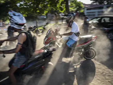 Orang-orang berkumpul di skuter listrik mereka untuk menghabiskan sore hari memamerkan aksi dan balap di Havana, Kuba, Jumat, 15 Juli 2022. Kuba telah dibanjiri dalam beberapa tahun terakhir dengan "motorinas", begitu skuter listrik ini disebut di pulau itu, sebuah mode bagi banyak orang, tetapi juga solusi untuk masalah transportasi dan kekurangan bahan bakar yang melanda negara Karibia itu. (AP Photo/Ramon Espinosa)