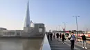 Pejalan kaki berjalan melewati London Bridge menuju Kota London di Inggris, Selasa (15/9/2020). Tingkat pengangguran di Inggris mengalami kenaikan untuk pertama kalinya sejak penerapan karantina wilayah (lockdown) pada Maret, data resmi menunjukkan pada Selasa (15/9). (JUSTIN TALLIS/AFP)