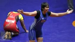 Pegulat putri Kalimantan Selatan Ridha W (biru) mengekspresikan kemenangannya atas Anita (Kaltim) di final gaya bebas kelas 63 kg melawan Anita (Kaltim) pada PON XIX di Arena Saparua Sport Park, Bandung, Sabtu (24/9). (Liputan6.com/Helmi Fithriansyah)