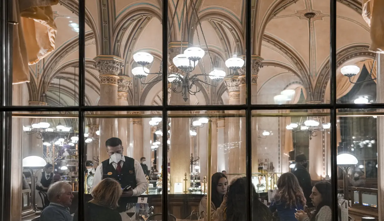 Orang-orang duduk di sebuah kafe di Wina, Austria, Minggu (21/11/2021). Pemerintah Austria mengumumkan penguncian nasional yang akan dimulai Senin (22/11). (AP Photo/Vadim Ghirda)