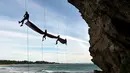 Sekelompok mahasiswa mengibarkan bendera Merah Putih berukuran besar menjelang perayaan Hari Ulang Tahun ke-77 Republik Indonesia di Pantai Lhoknga, Aceh, 16 Agustus 2022. Pengibaran bendera Merah Putih berukuran besar yang dilakukan pada sebuah tebing ini untuk memeriahkan Hari Ulang Tahun ke-77 Republik Indonesia. (CHAIDEER MAHYUDDIN/AFP)