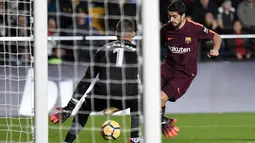 Pemain Barcelona, Luiz Suarez melakukan tendangan yang berusaha ditangkap kiper Villarreal, Sergio Asenjo pada jornada ke-15 La Liga di Stadion Ceramica, Minggu (10/12). Barca menyudahi pertandingan ini dengan kemenangan 2-0.  (JOSE JORDAN / AFP)