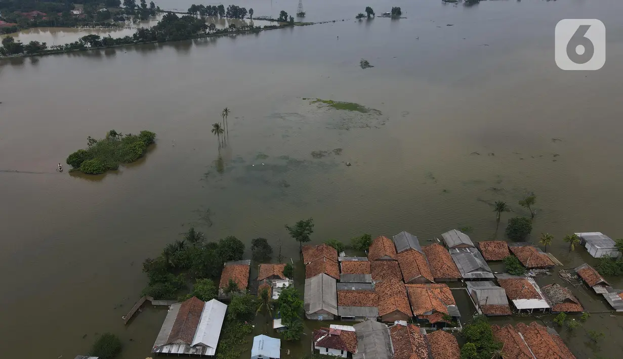 Foto udara suasana pemukiman warga yang terendam banjir menggunakan kamera nir-awak di Desa Karangligar dan Dusun Pengasinan kecamatan Teluk Jambe Barat, Kabupaten Karawang, Selasa (6/12/2022).  Banjir yang terjadi setelah hujan deras yang mengguyur sejak Minggu (4/12/2022) mulai berangsur surut. (merdeka.com/Imam Buhori)