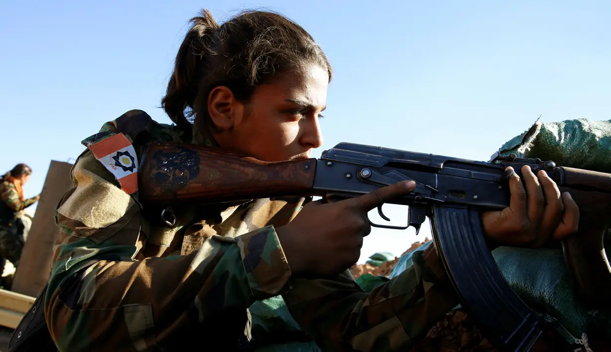 Seorang pejuang wanita Iran-Kurdi membidikan senjatanya saat ikut pertempuran melawan kelompok radikal Negara Islam (ISIS) di Bashiqa, dekat Mosul, Irak, Kamis (3/11). (Reuters/Ahmed Jadallah)
