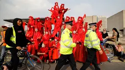 Aktivis lingkungan berdiri di atas halte bus saat melakukan blokade Jembatan Waterloo, London, Inggris (17/4). Aksi blokade ini untuk mendorong pemerintah berbuat lebih dalam mengatasi perubahan iklim yang terjadi. (AFP Photo/Tolga Akmen)