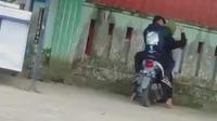 Pasangan mesum di atas moto di halaman pasar Montong Tuban. (Adirin/Liputan6.com)