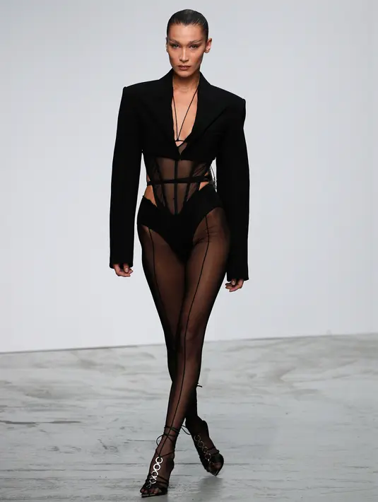 Model Bella Hadid mengenakan membawakan koleksi Spring 2020 dari Mugler dalam gelaran Paris Fashion Week, Rabu (25/9/2019). Bella Hadid  memadukan lingerie hitam transparannya dengan crop blazer berwarna senada. (AP Photo/Francois Mori)
