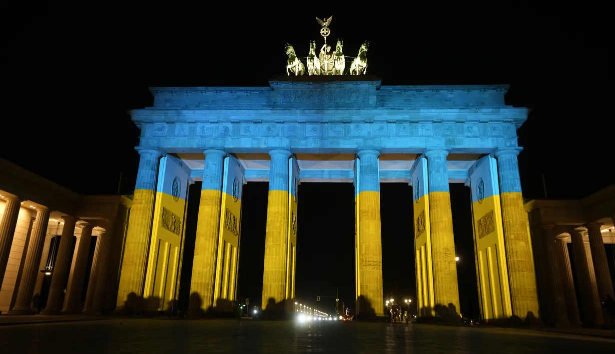 Gerbang Brandenburg diterangi dengan warna bendera Ukraina di Berlin, Jerman, Rabu (23/2/2022). Salah satu bangunan ikonik itu diterangi warna bendera nasional Ukraina, biru dan kuning untuk menunjukkan solidaritas selama ketegangan negera itu dengan Rusia. (AP Photo/Markus Schreiber)