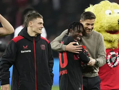 Pelatih Bayer Leverkusen, Xabi Alonso, merayakan kemenangan bersama Jeremie Frimpong saat melawan Fortuna Duesseldorf pada laga semifinal DFB Pokal di Stadion BayArena, Kamis (4/4/2024). (AP Photo/Martin Meissner)