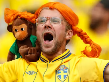 Seorang suporter Swedia memakai wig dan membawa boneka monyet saat mendukung timnya melawan Irlandia di pertandingan Grup E Euro 2016 di Stade de France, Saint-Denis, Paris, (13/6). (REUTERS/John Sibley)