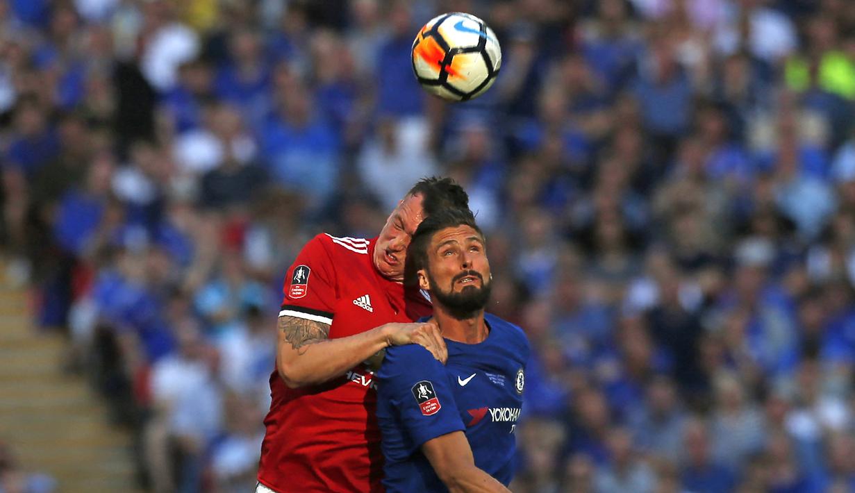 Pemain MU, Phil Jones (kiri), berebut bola diudara dengan pemain Chelsea, Olivier Giroud, dalam pertandingan final FA Cup yang berlangsung Wembley stadium (19/5/2018). (AFP/Ian Kington)