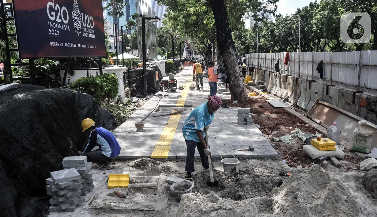 Pekerja menyelesaikan proyek revitalisasi trotoar di Jalan Medan Merdeka Selatan, Jakarta Pusat, Selasa (22/11/2022). Pemprov DKI Jakarta mengalokasikan anggaran sebesar Rp 171 miliar dalam Rancangan Anggaran Pendapatan dan Belanja Daerah (RAPBD) DKI Jakarta 2023 untuk revitalisasi trotoar di Ibu Kota. (merdeka.com/Iqbal S. Nugroho)