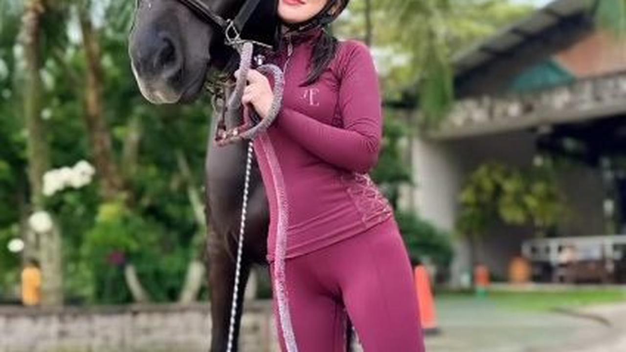 Celine memakai busana latihan lengkap, termasuk sepatu boots berkuda dan helm.&nbsp;