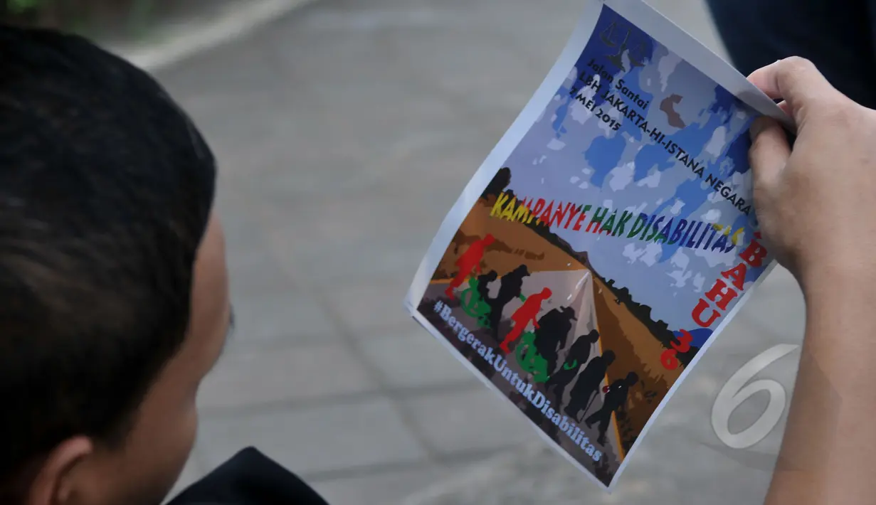 Selebaran tentang dukungan kepada penyandang disabilitas dibagikan kepada warga yang melintas di kawasan Bundaran HI, Jakarta, Kamis (7/5/2015). (Liputan6.com/Johan Tallo)