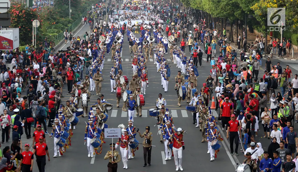 Grup marching band anggota kepolisian RI memeriahkan Parade Asian Games 2018 yang melintasi Jalan MH Thamrin, Jakarta, Minggu (15/5). Parade digelar oleh Inasgoc untuk 100 hari jelang Asian Games. (Liputan6.com/Arya Manggala)