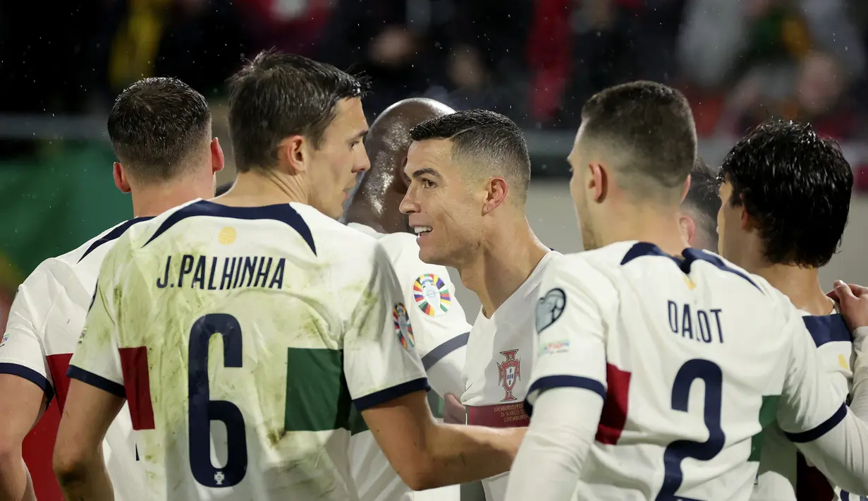 Para pemain Timnas Portugal merayakan gol yang dicetak Cristiano Ronaldo ke gawang Luksemburg pada laga Grup J Kualifikasi Euro 2024 di Stade de Luxembourg, Luksemburg (26/3/2023). Portugal menjadi tim tersubur dengan mengoleksi 10 gol tanpa kebobolan di Grup J. Cristiano Ronaldo dkk sukses menghajar Liechtenstein 4-0 dan Luksemburg 6-0. (AP Photo/Olivier Matthys)