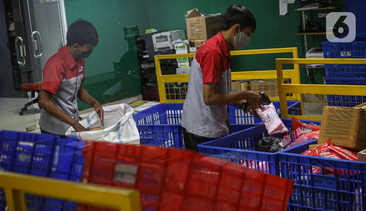 Pekerja memilah paket kiriman barang di Kantor Cabang JNE, Jakarta, Kamis (30/12/2021). Supply Chain Indonesia (SCI) memprediksi peningkatan pengiriman barang pada akhir tahun ini mencapai 20 persen untuk ke wilayah luar Pulau Jawa dan Bali. (Liputan6.com/Faizal Fanani)