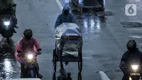 Pedagang melintas saat hujan mengguyur Jakarta, Senin (26/10/2020). BPBD DKI Jakarta mengeluarkan peringatan dini cuaca berupa potensi terjadinya hujan lebat disertai petir dan angin kencang dampak dari siklon tropis Molave hingga 27 Oktober 2020. (merdeka.com/Iqbal S. Nugroho)