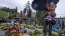 Tetiana Rurak (25) mengunjungi makam suaminya yang merupakan seorang tentara, Volodymyr Rurak, bersama putrinya yang berusia satu setengah tahun setelah suaminya itu terbunuh dalam perang dengan Rusia di pemakaman Lychakiv, Lviv, Ukraina, Selasa (5/4/2022). (AP Photo/Nariman El-Mofty)