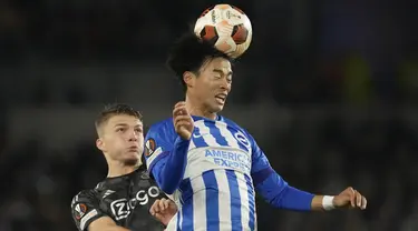 Gelandang Brighton & Hove Albion, Kaoru Mitoma melompat untuk mengejar bola bersama penyerang Ajax Steven Berghuis pada matchday 3 Grup B Liga Europa 2023/2024 di The American Express Community Stadium, Jumat (27/10/2023) WIB. (AP Photo/Frank Augstein)