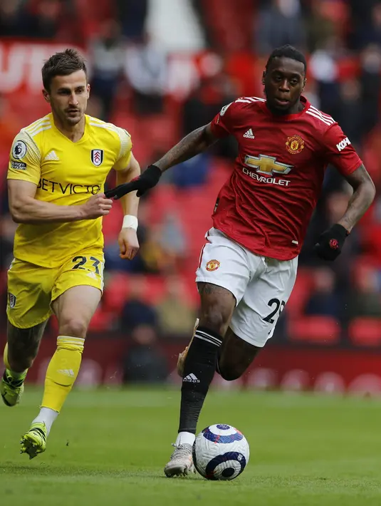 Gelandang Fulham, Joe Bryan berebut bola dengan bek Manchester United (MU), Aaron Wan-Bissaka pada pekan 37 Liga Inggris di Stadion Old Trafford, Rabu (19/5/2021) dinihari WIB. MU kembali gagal menang setelah ditahan imbang 1-1 oleh tamunya Fulham. (AP Photo/Phil Noble, Pool)