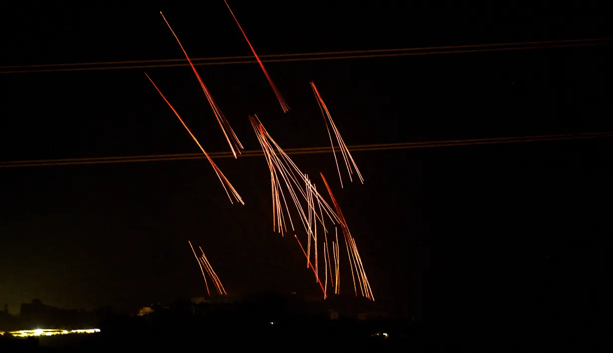Gambar yang diambil dari posisi dekat Sderot di sepanjang perbatasan Israel dengan Jalur Gaza pada 4 November 2023 ini menunjukkan suar yang dijatuhkan pasukan Israel di atas daerah kantong Palestina di tengah pertempuran yang sedang berlangsung antara Israel dan Hamas. (YURI CORTEZ / AFP)