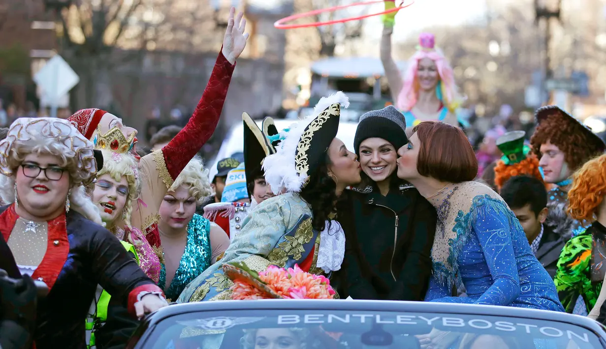 Aktris Mila Kunis (tengah) dicium oleh Amira Weeks (kiri) dan Jacques Berguig dalam sebuah parade di Cambridge (25/1). (AP Photo / Charles Krupa)