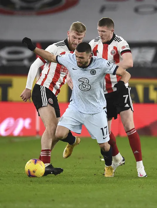Gelandang Chelsea, Mateo Kovacic berusaha mengontrol bola dari kawalan dua pemain Sheffield United pada pertandingan lanjutan Liga Inggris di stadion Bramall Lane, Inggris, Senin (8/2/2021). Chelsea kini mengumpulkan 39 poin dari 23 pertandingan. (Oli Scarff / Pool via AP)