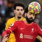 Pemain Liverpool, Mohamed Salah mendappat gangguan dari dua pemain Wolverhampton pada laga di ajang Liga Inggris 2021/2022. (JUSTIN TALLIS / AFP)