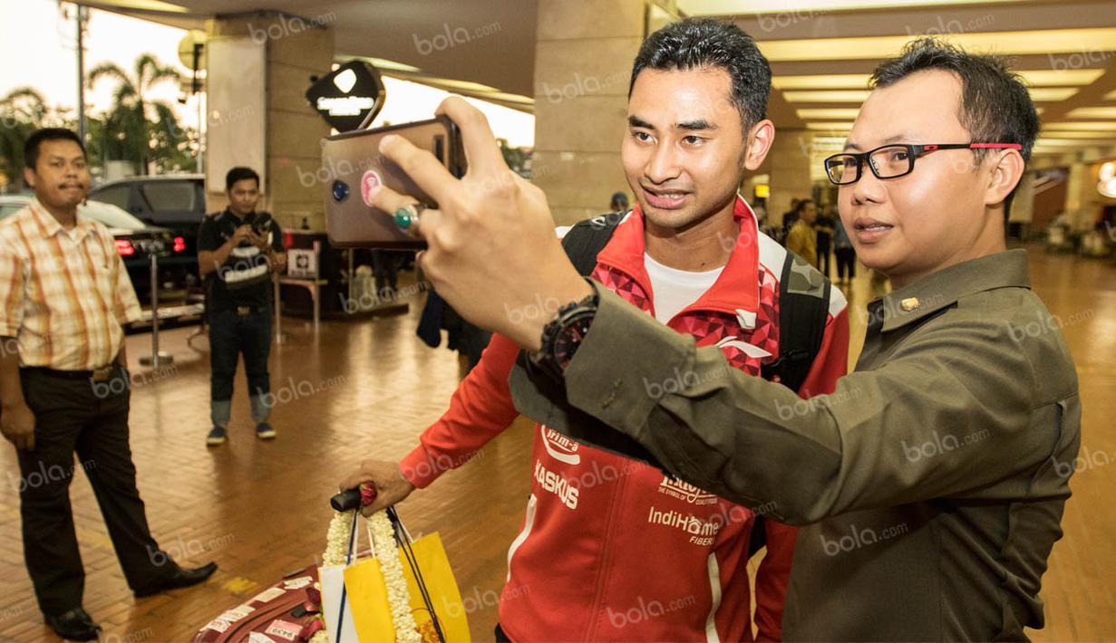 Pebulutangkis tim Piala Thomas Indonesia, Tommy Sugiarto, selfie bersama warga saat tiba di Bandara Soekarno-Hatta. Meski lelah para pebulutangkis Indonesia tetap ramah menyapa para warga di Bandara. (Bola.com/Vitalis Yogi Trisna)