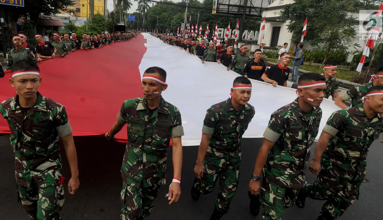 Anggota TNI POLRI  membawa bendera raksasa saat gelaran Festival Merah-Putih (FMP) 2018 di kawasan Air Mancur, Bogor,  Minggu (5/8). Bendera tersebut berukuran panjang 117 meter dan lebar 5 meter. (Merdeka.com/Arie Basuki)