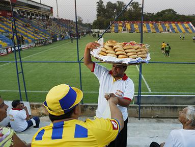 Pedagang kue tradisional khas Paraguay bernama Chipa menjajakan dagangan dengan bebas di stadion kandang Deportivo Capiata. (AP Photo/Jorge Saenz) 