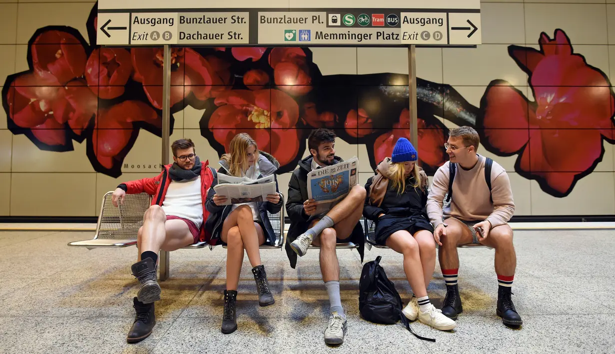 Penumpang tanpa mengenakan celana selama No Pants Subway Ride di stasiun bawah tanah Moosbach, Jerman, Minggu (7/1). Hari Tanpa Celana di Kereta dimulai tujuh anak muda New York pada 2002 yang hanya ingin menegrjai temannya. (Andreas Gebert/dpa via AP)