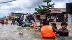 Para relawan membantu warga melewati derasnya banjir di Makassar pada 12 Februari 2025. (DAENG MANSUR/AFP)