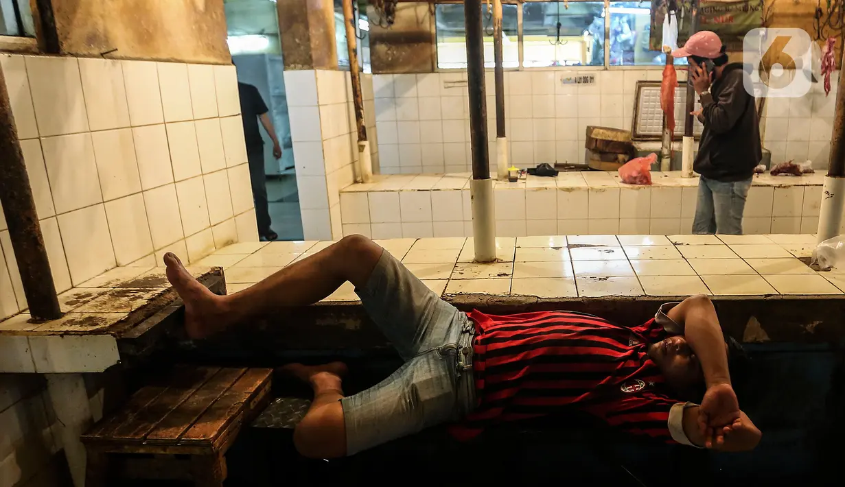Seorang pria tidur di los pedagang daging yang kosong akibat aksi mogok pedagang di Pasar Kebayoran, Jakarta, Rabu (20/1/2021). Aksi mogok jualan para pedagang daging sapi sebagai bentuk protes kepada pemerintah atas tingginya harga daging sapi sejak akhir 2020. (Liputan6.com/Johan Tallo)