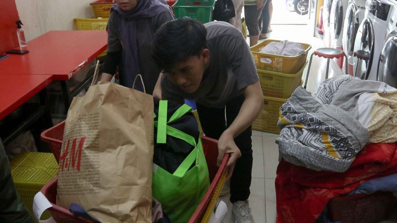 Kesibukan pekerja di tengah tingginya permintaan pada sebuah penyedia jasa laundry di kawasan Ampera Raya, Jakarta, Rabu (17/4/2024).&nbsp;Permintaan layanan penatu pakaian atau laundry meningkat setelah libur panjang Lebaran. Liputan6.com/Herman Zakharia