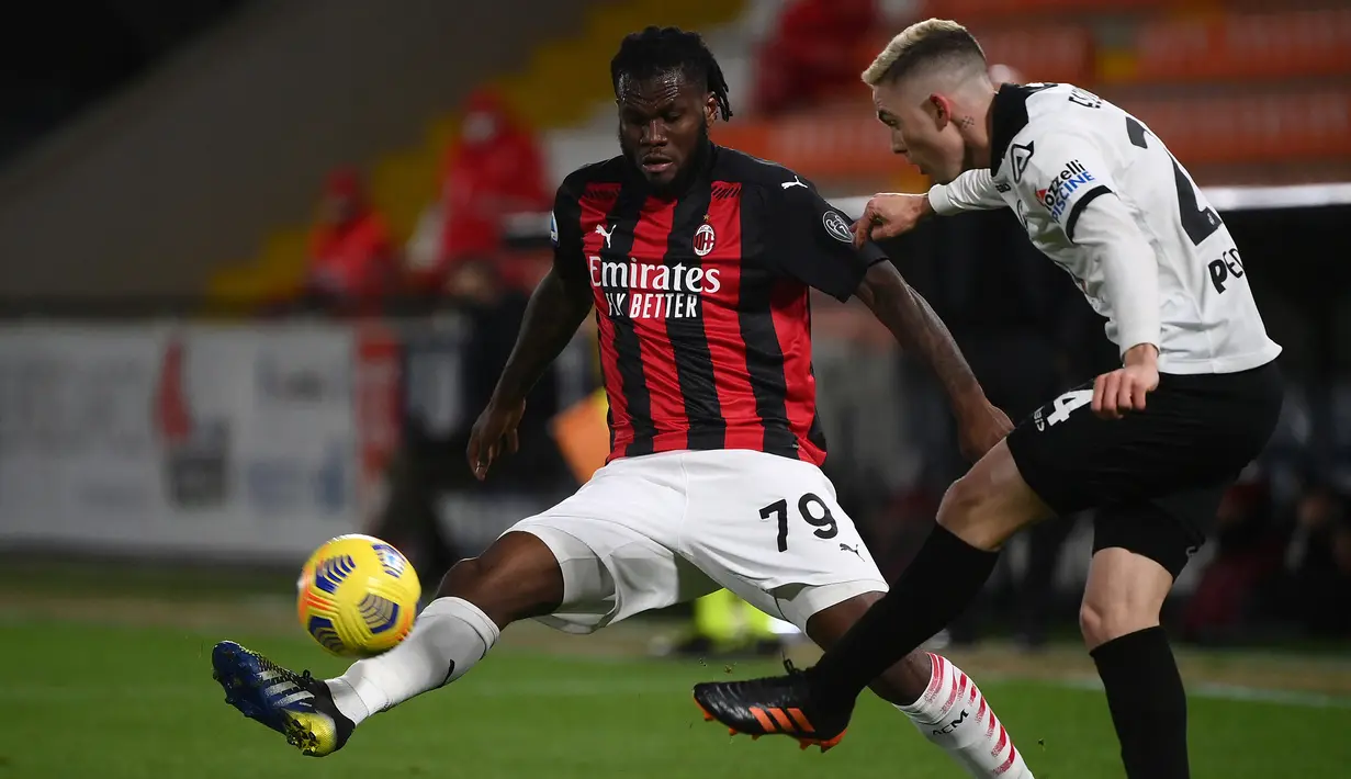 Gelandang Spezia, Nahuel Estevez (kanan) melepaskan umpan di depan gelandang AC Milan, Franck Kessie dalam laga lanjutan Liga Italia 2020/21 pekan ke-22 di the Alberto-Picco Stadium, La Spezia, Sabtu (13/2/2021). Spezia menang 2-0 atas AC Milan. (AFP/Marco Bertorello)