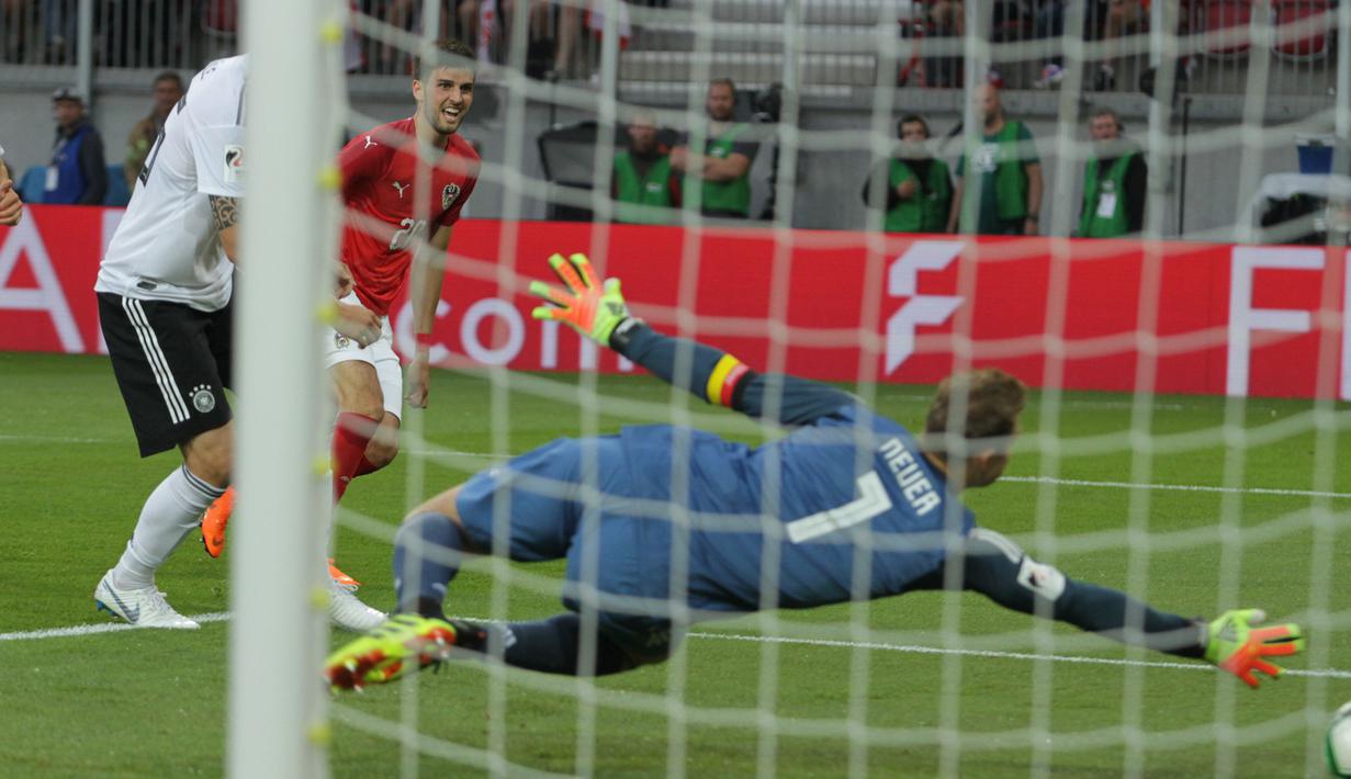 Kiper Jerman, Manuel Neuer, berusaha menepis bola tendangan gelandang Austria, Florian Grillitsch, pada laga persahabatan di Stadion Woerthersee, Klagenfurt, Sabtu (2/6/2018). Austria menang 2-1 atas Jerman. (Bola.com/Reza Khomaini)