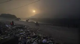 Anak-anak tunawisma mengumpulkan sampah untuk dijual kembali saat kebakaran besar melanda tempat pembuangan sampah Ghazipur di New Delhi, India (28/3/2022). (AP Photo/Manish Swarup)