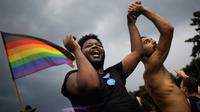 Dua pria menari saat mengikuti parade ‘Gay Pride’ di Berlin, Jerman, Sabtu (22/7). Pendukung gay dan lesbian berpesta setelah Parlemen Jerman melegalkan pernikahan sesama jenis. (AP/Markus Schreiber)