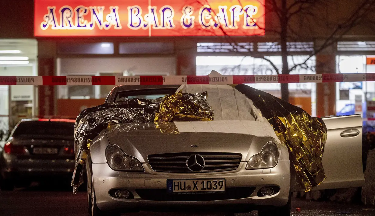 Sebuah mobil yang rusak terparkir di tempat penembakan di depan sebuah bar di Hanau, Jerman, Kamis, (20/2/2020). Polisi di Jerman menangkap satu orang terkait penembakan massal di dua bar hookah di Hanau, Rabu malam.  (AP Photo/Michael Probst)