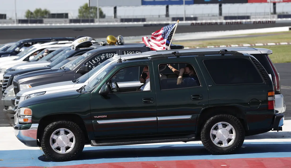 Mahasiswa Cabarrus Early College of Technology duduk dalam mobil bersama keluarga mereka saat menjalani wisuda di Charlotte Motor Speedway, Concord, North Carolina, Amerika Serikat, Jumat (12/6/2020). Ribuan mahasiswa menjalani wisuda di arena NASCAR. (AP Photo/Gerry Broome)